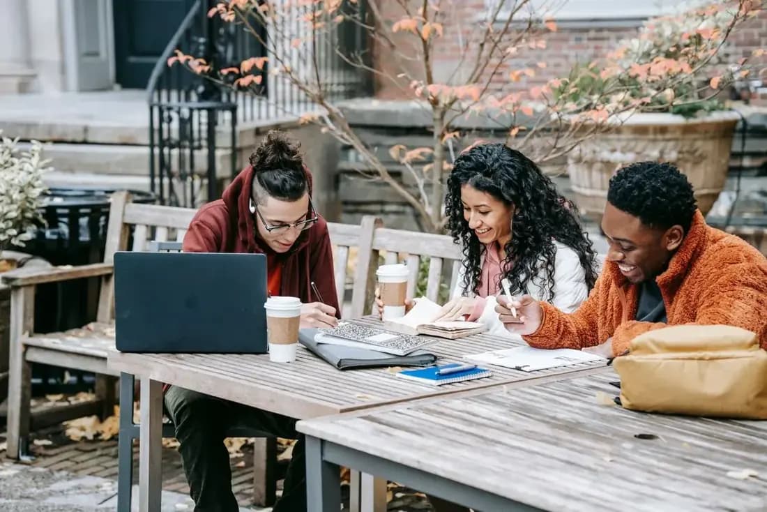 Group of students working together at a table with a laptop and notes
